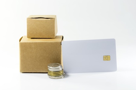 Cardboard box with Coins and credit cards on isolatedの写真素材
