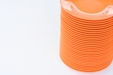 Melamine Orange Plate stack on white background.の写真素材