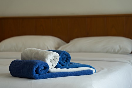 Blue and white towels on bed in hotel bedroom.  Concept interior decorationの写真素材