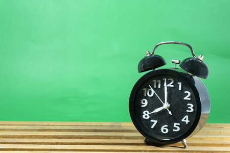 Old clock black on wood with green background.  Vintage style