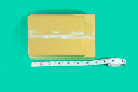 Top view Cardboard boxes with tape measure on green background.の写真素材