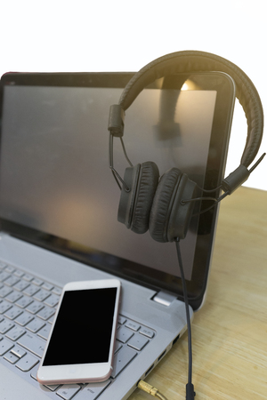 Hanging headphones on a laptop and smart phone is placed on the keyboard./concept work about soundの写真素材