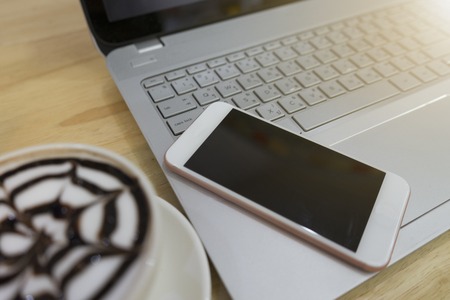 Work in a coffee shop with smartphone and Laptop on tableの写真素材