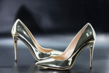 Golden high heel shoes lady on black background.の写真素材