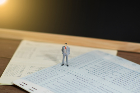 miniature business man standing on account book. All is not clear.の写真素材