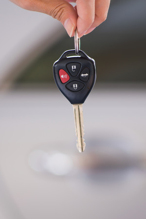 woman's hand holding modern car keys ready for rental - Concept of transportation with automobileの写真素材