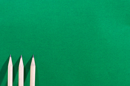 Three pencils placed on a green background or green board.の写真素材