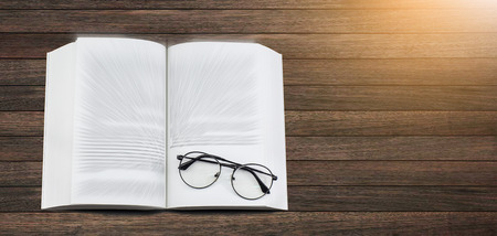Glasses on text book on desk. Education concept.の写真素材