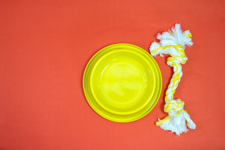 Bowl and rope for bite is pet accessories on red background.の写真素材