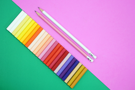 Row colorful chalk pastels on green background and pencils on pink background.の写真素材