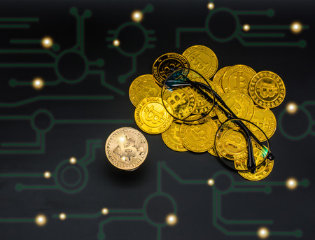 Glasses on the Bitcoin Gold background image is a graph. The concept of electronic money investingの写真素材