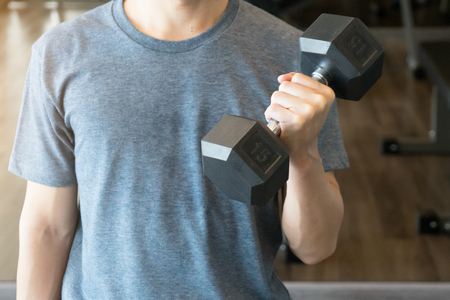 A man workout with dumbbell for muscles at gymの写真素材