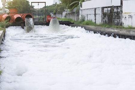 Drainage pipe with water flowing into the riverの写真素材