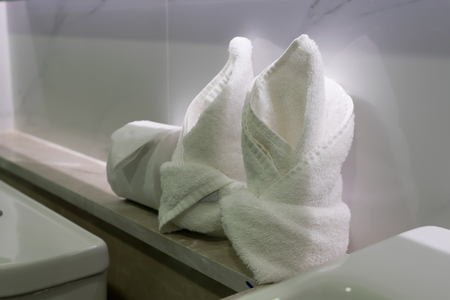 White towels and tissue roll in bathroom.の写真素材