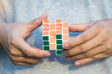 Bangkok, Thailand - May 10, 2018: Hand holding and playing Rubik's Cube. Rubik's cube invented by a Hungarian architect Erno Rubik in 1974.のeditorial素材