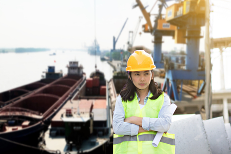 Engineering wearing yellow helmet and working at construction site about transportation of international logistics backgroundの写真素材
