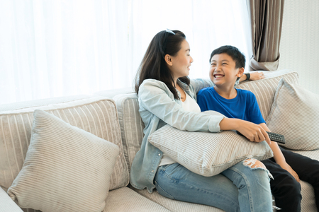 Happy family time. Mother and son relaxing in living room at home.の写真素材