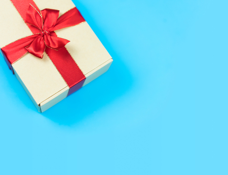 Gift box with red ribbon on color background. Object for Christmas day or Birthday present.の写真素材