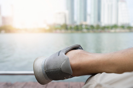 Close up run shoes with legs of athlete sitting after exercise. Workout concept