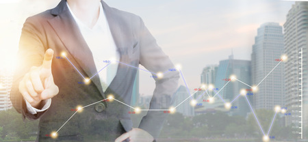 Double exposure of Business people with graph on modern city.の写真素材