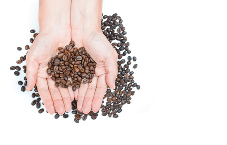 Hand holding coffee beans on white background.の写真素材