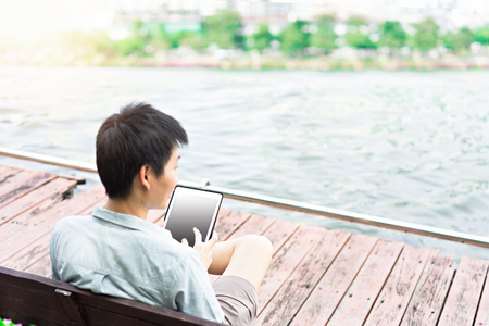Asian man using tablet in publicの写真素材