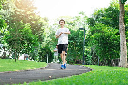 Asian Man running at public park. Workout concept