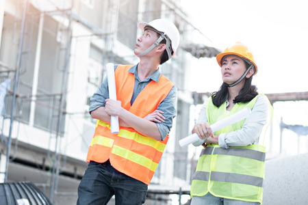Team of engineers wearing yellow helmet and working at construction site