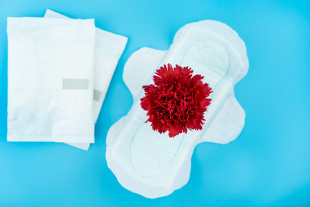 Red flowers on sanitary napkin with light blue backgroundの写真素材