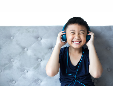 Little boy listening to music on bed at bedroom for relax