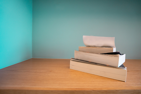 Stack books on table with vintage background.
