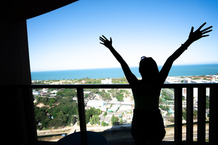 Silhouette happy woman looking sea view at the morning
