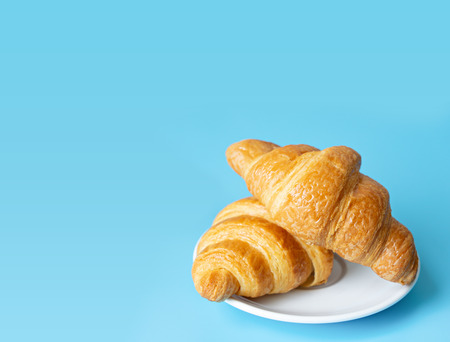 Croissant in a white plate on color backgroundの写真素材