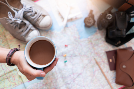 Hand hold coffee and planning for travelの写真素材