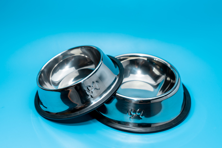 Stainless bowl on blue background.  Pet supplies conceptの写真素材