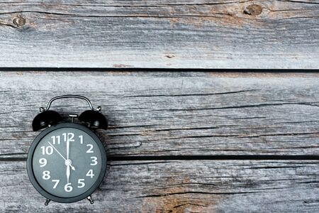 Alarm clock with copy space on wooden background.