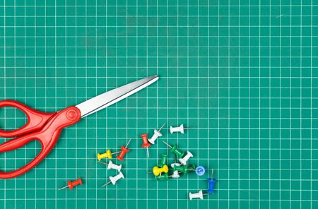 Scissors and Green Cutting mat on desk.