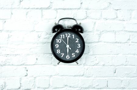 Alarm Clock on white bricks background