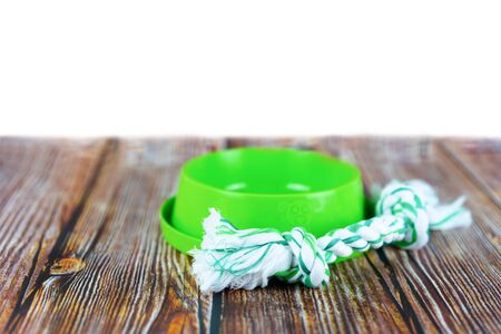 Pet accessories concept.  Pet bowl with toy on wooden with copy space.の写真素材