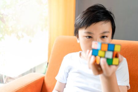 Bangkok, Thailand - October 1, 2019: Close-up eyes little boy play Rubik's Cube. Rubik's cube invented by a Hungarian architect Erno Rubik in 1974.のeditorial素材