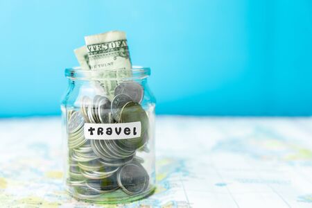 Saving money in a glass jar for travel on mapの写真素材