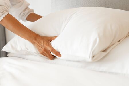 Female Hand set up white bed sheet in bedroom