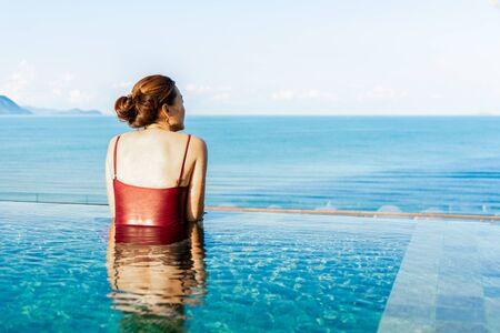 Women relax in swimming pool with mountain view and sunrise