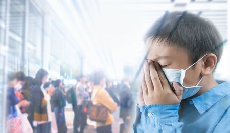Boy wearing health masks on blur group people backgroundの写真素材