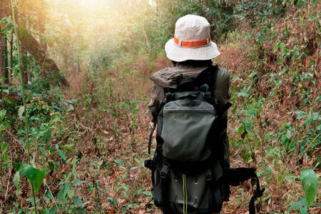 Hipster woman with backpacker hiking at the forest
