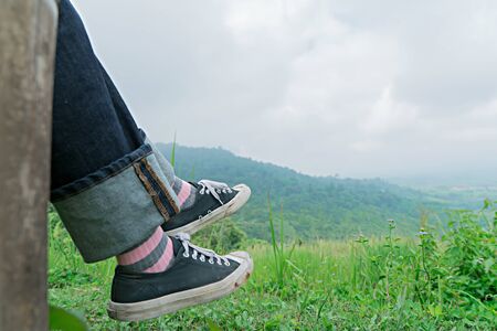 Traveler foot with green mountain.  Relax outdoor conceptの写真素材