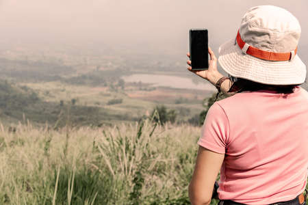 Tourists taking photo of natural sceneryの写真素材