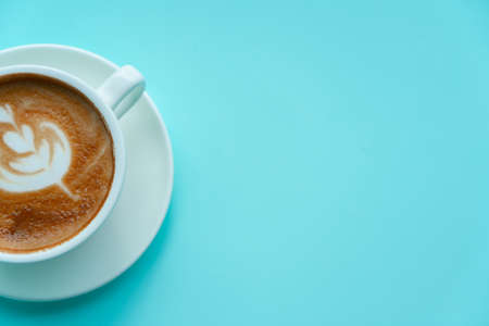Hot coffee with late art on blue backgroundの写真素材