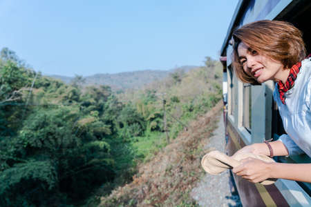 Woman looks out from window traveling by train