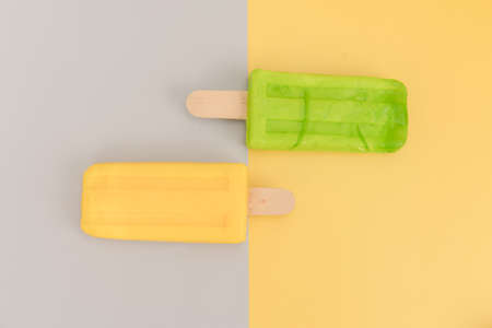 Ice cream stick on gray and yellow background.の写真素材